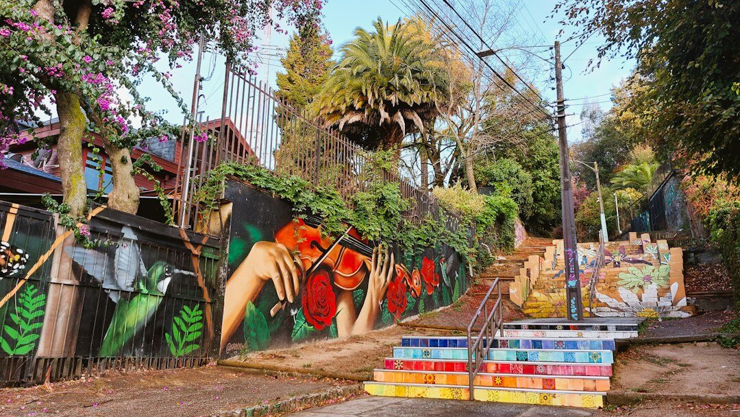 Narrow alley covered in colorful street art murals in Chile